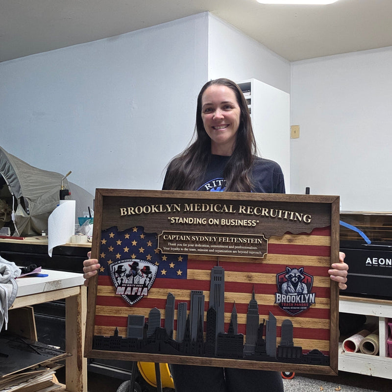Person holding a wooden sign in a workshop setting