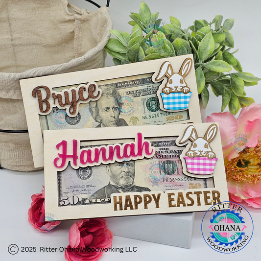 A wooden Easter money holder with a cute bunny design, featuring slots for cash and checks, personalized with the name 'Bryce' and 'Hannah'. The holder is displayed with 'Happy Easter' text and colored in pink and blue.