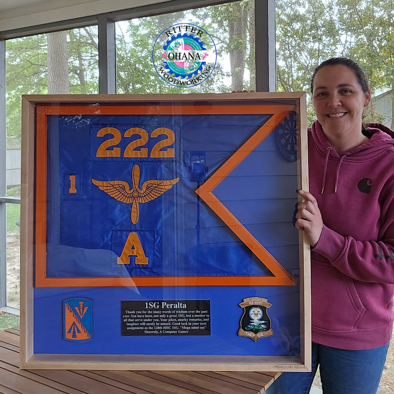 a person standing next to a wooden plaque with a military guldon flag 