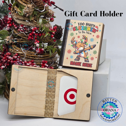 Personalized wooden Christmas gift card holder for kids featuring a colorful dabbing reindeer, Too Busy Sleighin' to Be Nice saying, custom name, and reusable magnetic wooden money holder.