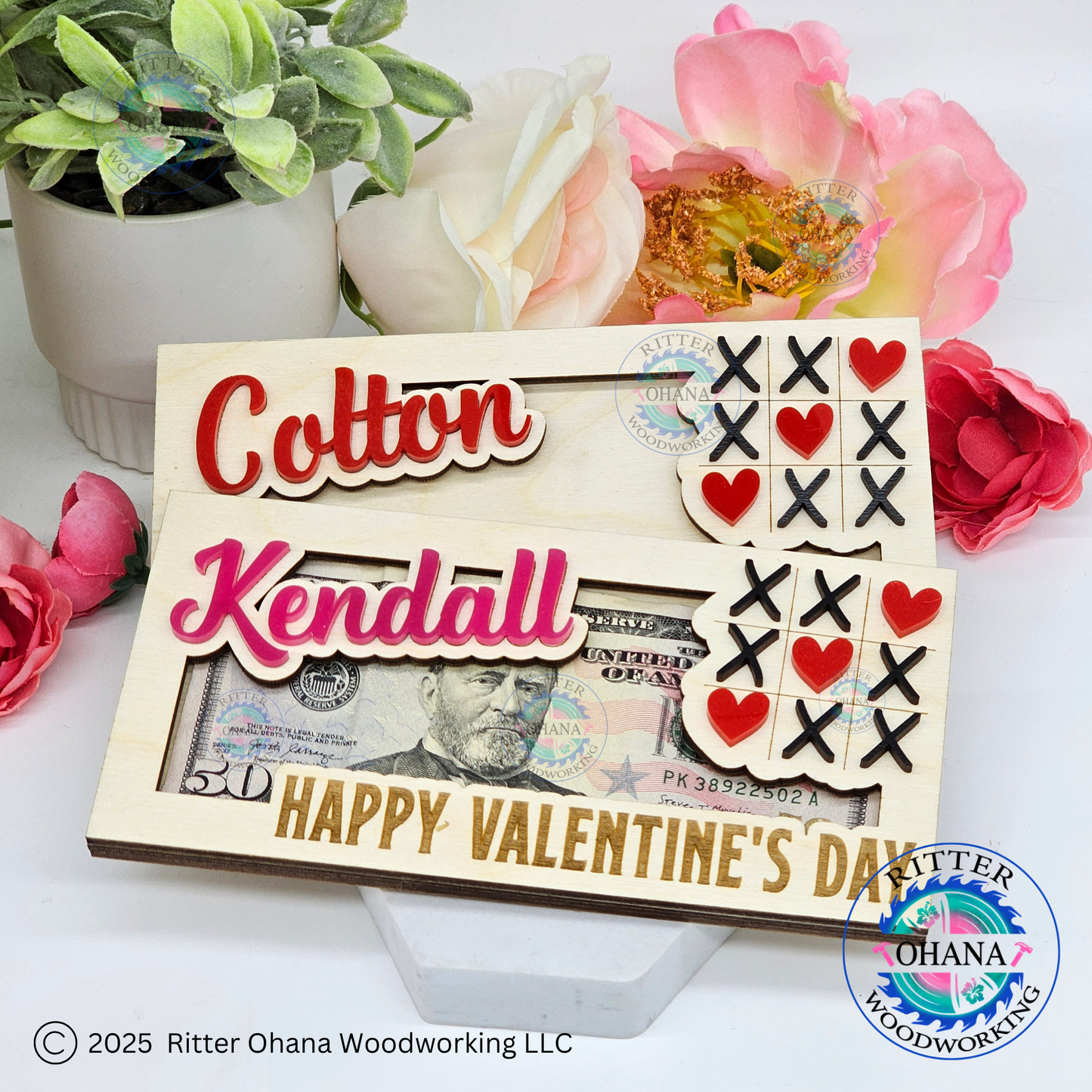 Personalized wooden Valentine's Day money holder with tic-tac-toe game and hearts, customized with a name, displayed on a table with flowers in the background.