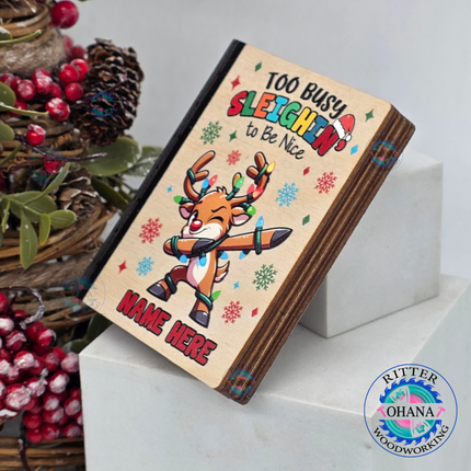 Personalized wooden Christmas gift card holder for kids featuring a colorful dabbing reindeer, Too Busy Sleighin' to Be Nice saying, side view 
