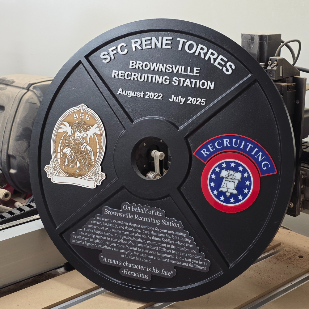 Black wood plaque with engraved text and logos, featuring 'SFC Rene Torres' and 'Brownsville Recruiting Station'. 45lbs weight plate, round shape